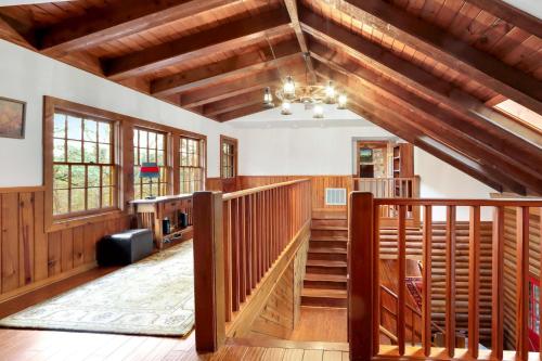 a living room with wooden stairs and a vaulted ceilings at Mill Lodge in Wimberley