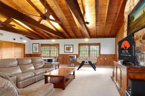 a living room with a couch and a pool table at Mill Lodge in Wimberley