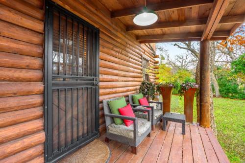 a wooden deck with two chairs and a door at Mill Lodge in Wimberley