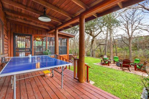 a ping pong table on a deck with a house at Mill Lodge in Wimberley