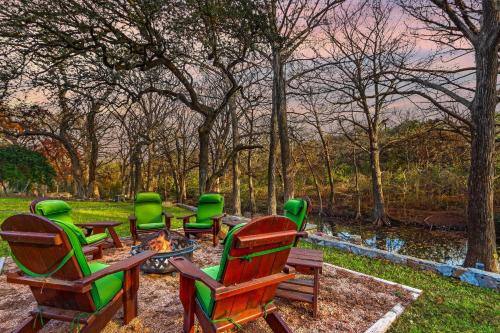 a group of green chairs sitting around a fire pit at Mill Lodge in Wimberley
