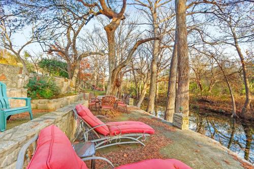 a couple of benches and chairs next to a river at Mill Lodge in Wimberley