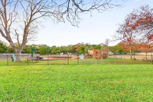 a fence in front of a park with a playground at Mill Lodge in Wimberley