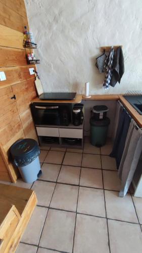 a small kitchen with a stove and a tiled floor at maison de vigneron in Mareugheol