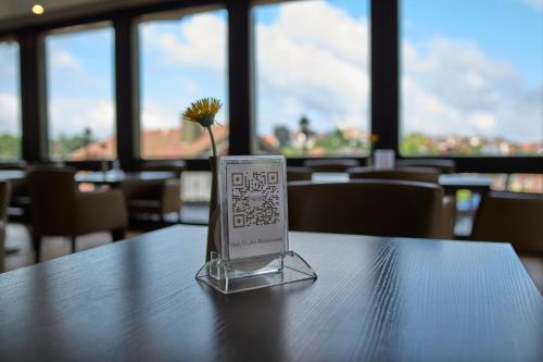 a vase with a flower sitting on top of a table at LuCA Hotel in Bodenmais