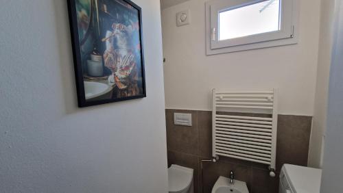 a bathroom with a painting on the wall and a toilet at Terrazza sull'Alba in Pisa