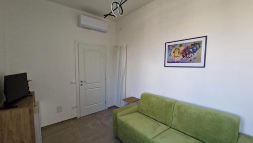 a living room with a green couch and a tv at Terrazza sull'Alba in Pisa