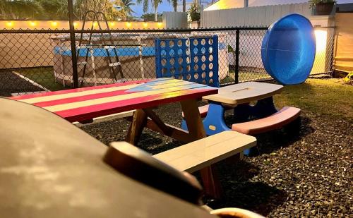 two picnic tables and chairs next to a fence at Casa Lula Beach Retreat - Fenced backyard in Arecibo