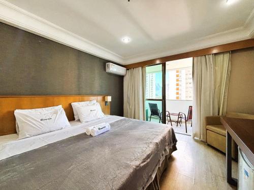 Un dormitorio con una cama grande y un balcón. en Apartamento com Estrutura de Hotel na Barra, en Río de Janeiro