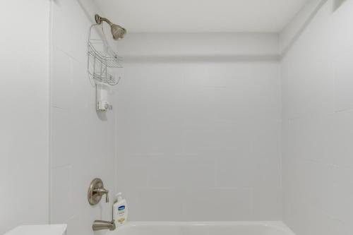 a white bathroom with a sink and a shower at Logan Square Urban Oasis: 2 Mi to Local Hotspots! in Chicago