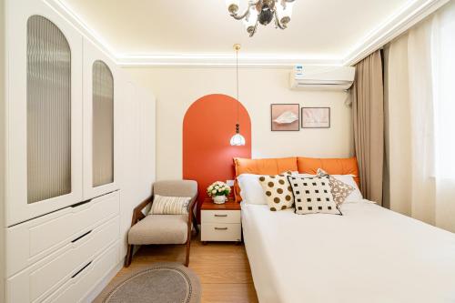 a bedroom with a white bed and a chair at Tonight Homestay Jing'an Temple Branch Shanghai in Shanghai