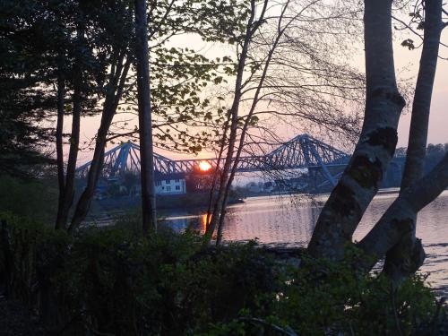 a bridge over a river with the sun setting at Falls of Lora Hotel in Oban
