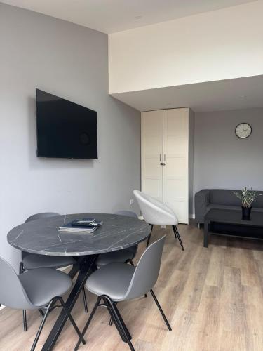 a dining room with a table and chairs and a television at Ravenscourt Rooms by Brabazon Rooms in Bristol