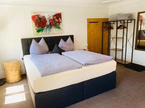 a bedroom with a large bed with blue pillows at Gasthof goldener Adler Riefensberg in Riefensberg