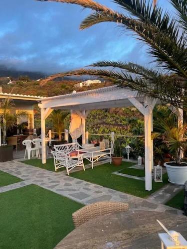 a pergola with a table and chairs on a lawn at House with 2 Bedrooms in Los Llanos de Aridane in Los Llanos de Aridane