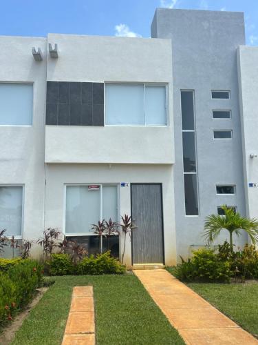 a white building with a door in front of it at Acapulco Diamante in Cedro