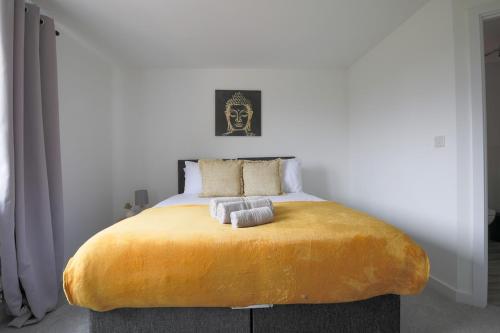 a bedroom with a large bed with two towels on it at The Haven – Modern 4-Bed Home with Garden in Cardiff