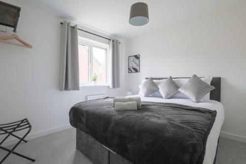 a bedroom with a bed with white walls and a window at The Haven – Modern 4-Bed Home with Garden in Cardiff