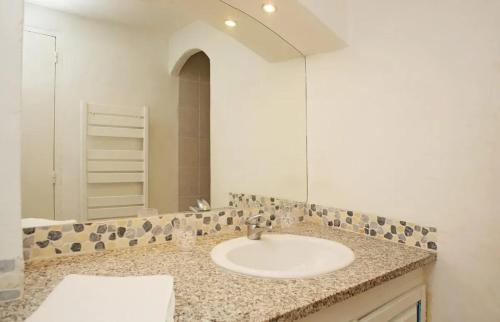 a bathroom with a sink and a mirror at Maison charmante près des vignes - 80 m² in La Garde-Freinet