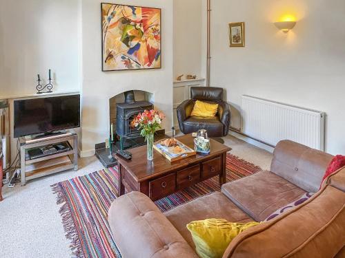 a living room with two couches and a fireplace at Enginemans Cottage in Bishop Auckland