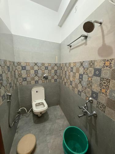 a small bathroom with a toilet and a shower at Vedic Villa in Ayodhya