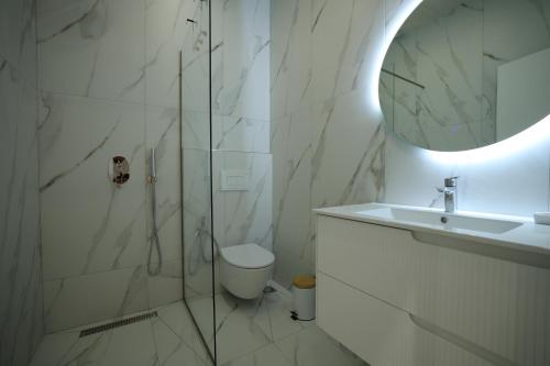 a bathroom with a shower and a toilet and a sink at Rooms Kruja City in Krujë