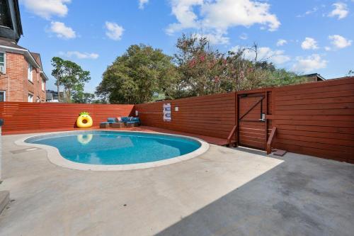 a swimming pool in a backyard with a wooden fence at Stylish 2BR Saltwater Pool in Houston