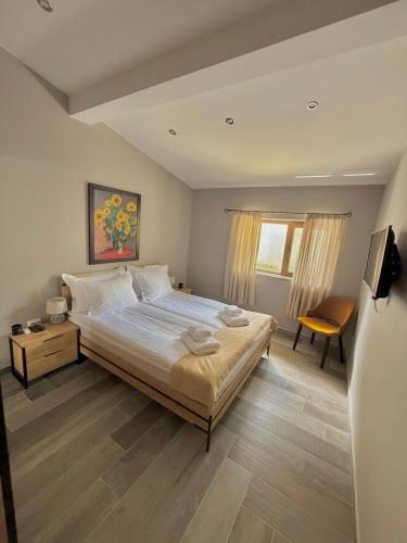a bedroom with a large bed and a chair at Вила Рафаела-Мартина in Dobrinishte