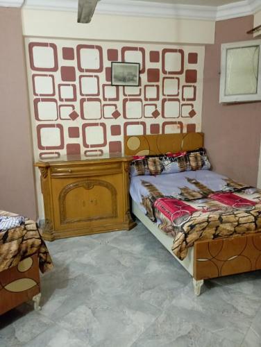 a bedroom with a bed and a wall with a picture at sidi bashr el tram street ali abi bash in Banī Ghālib