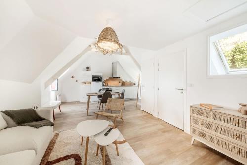 Una sala de estar blanca con un sofá y una mesa. en Bord de l'eau 6 - Sea view - 3 people, en Cancale