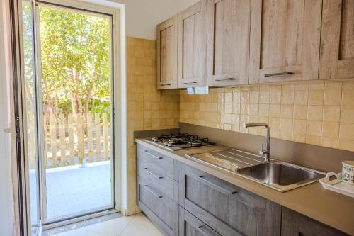 a kitchen with wooden cabinets and a sink and a window at Casa Carmen in Stazione di Paestum