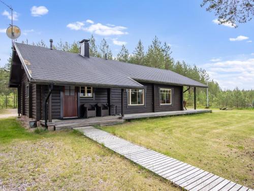 a small cabin with a porch in a field at Holiday Home Kaunotar by Interhome in Savitaipale