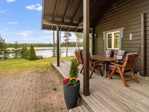 a wooden deck with a table and chairs on a house at Holiday Home Kaunotar by Interhome in Savitaipale