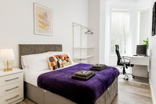 a bedroom with a bed with purple sheets and a desk at Manygates House by Alt-Stay - Wakefield Budget Friendly Contractor and Relocation Accommodation - Private Room with Parking, Fast Wi Fi, In Room Tea and Coffee, Shared Kitchen, Bathrooms and Lounge - Long Stay Ready with Weekly and Monthly Rates in Wakefield