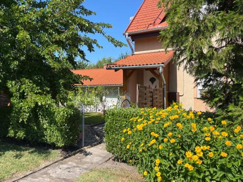 a house with a hedge and flowers in front of it at Apartment Pajtas 1 by Interhome in Balatonfenyves