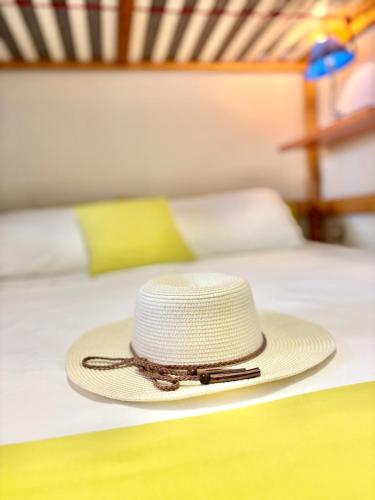 a straw hat sitting on top of a bed at Casa Aaron - Monolocale con veranda sul mare in Stintino