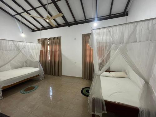 Un dormitorio con dos camas y un techo. en Three Brothers Villa, en Mirissa