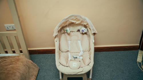 a baby stroller sitting in a room next to a bed at NJIRO 4BDR FAMILY HOME NEAR RESTURANTs AFCON EXERCISE Field in Arusha