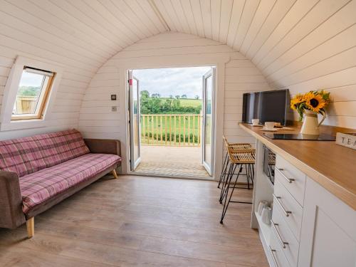 Una sala de estar con un sofá y un televisor en Cwmporthman Farm Cwtch-Uk34700, en Blaenporth