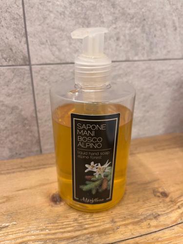 a bottle of soap sitting on a wooden table at BeB LUCA76 in Avise
