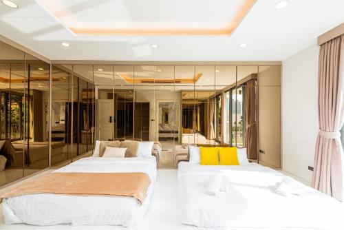 2 Betten in einem Zimmer mit Spiegeln in der Unterkunft Modern Luxury Poolhaus with Lift in Klong Toi