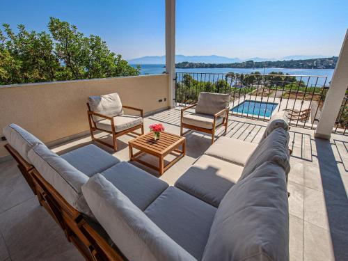 a couch on a patio with a view of the water at Holiday Home Sova by Interhome in Nečujam
