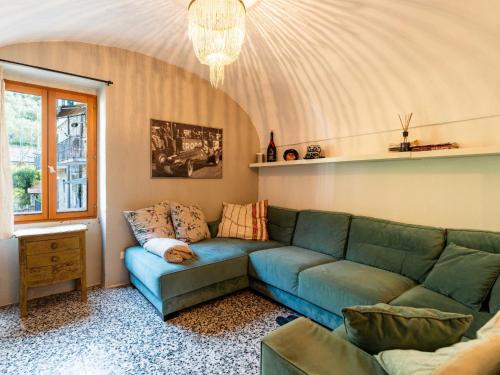 a living room with a blue couch and a window at Apartment A Dutch Place by Interhome in Airole