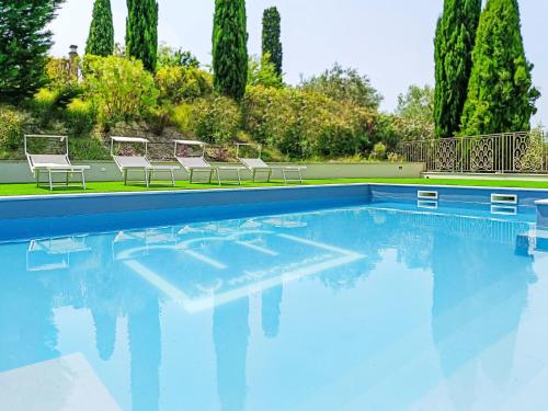 CollescipoliにあるVilla Umbriancevilla by Interhomeの青い水と椅子が備わるスイミングプール
