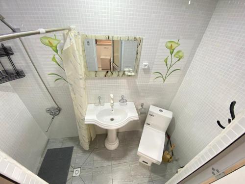 un bagno bianco con lavandino e specchio di BAHORONA Family Guest House a Khiva