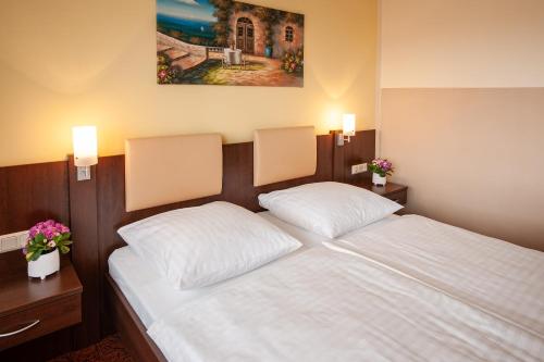 a bedroom with a bed with two white pillows at LuCA Hotel in Bodenmais