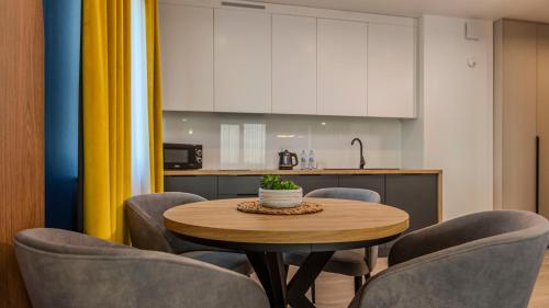 a dining room with a table and chairs and a kitchen at Marand Loft in Zaczernie