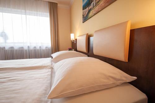 a hotel room with two beds and a window at LuCA Hotel in Bodenmais