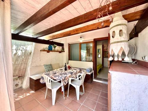 a dining room with a table and chairs at Casa Aaron - Monolocale con veranda sul mare in Stintino