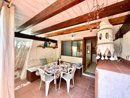 a dining room with a table and chairs on a patio at Casa Aaron - Monolocale con veranda sul mare in Stintino